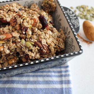 Best Crunchy and Chunky Granola in a baking dish with a tablespoon of cinnamon