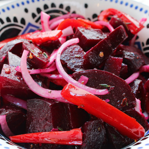 pickled beet salad in a blue bowl close up