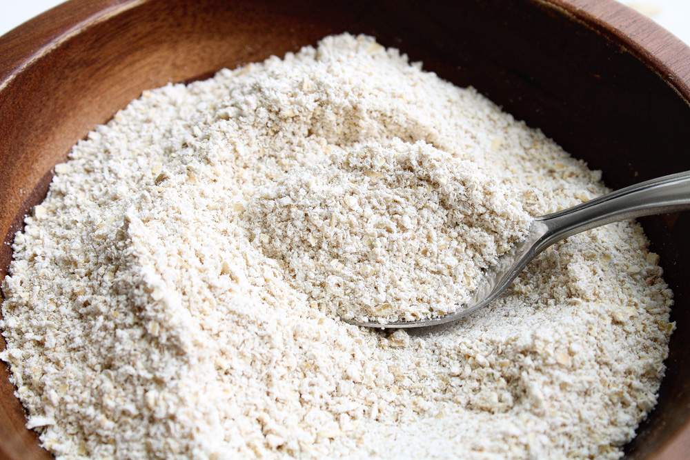 How to Make Oat Flour flour in a bowl with spoon
