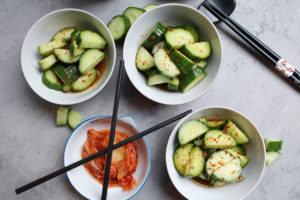 Korean cucumber salad in small bowls with kimchi