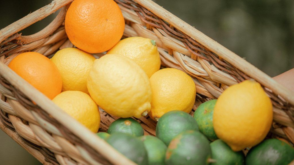 oranges, limes, and lemons in a woven basket