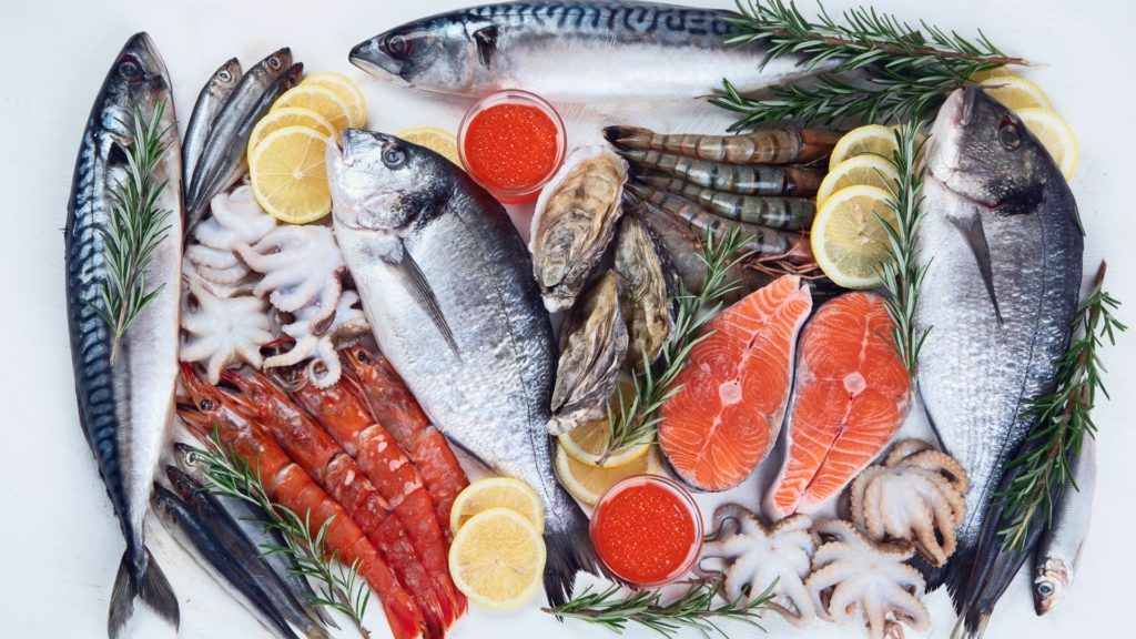 whole fish, salmon fillets, prawns, and other shellfish, lemon slices, sprigs of rosemary