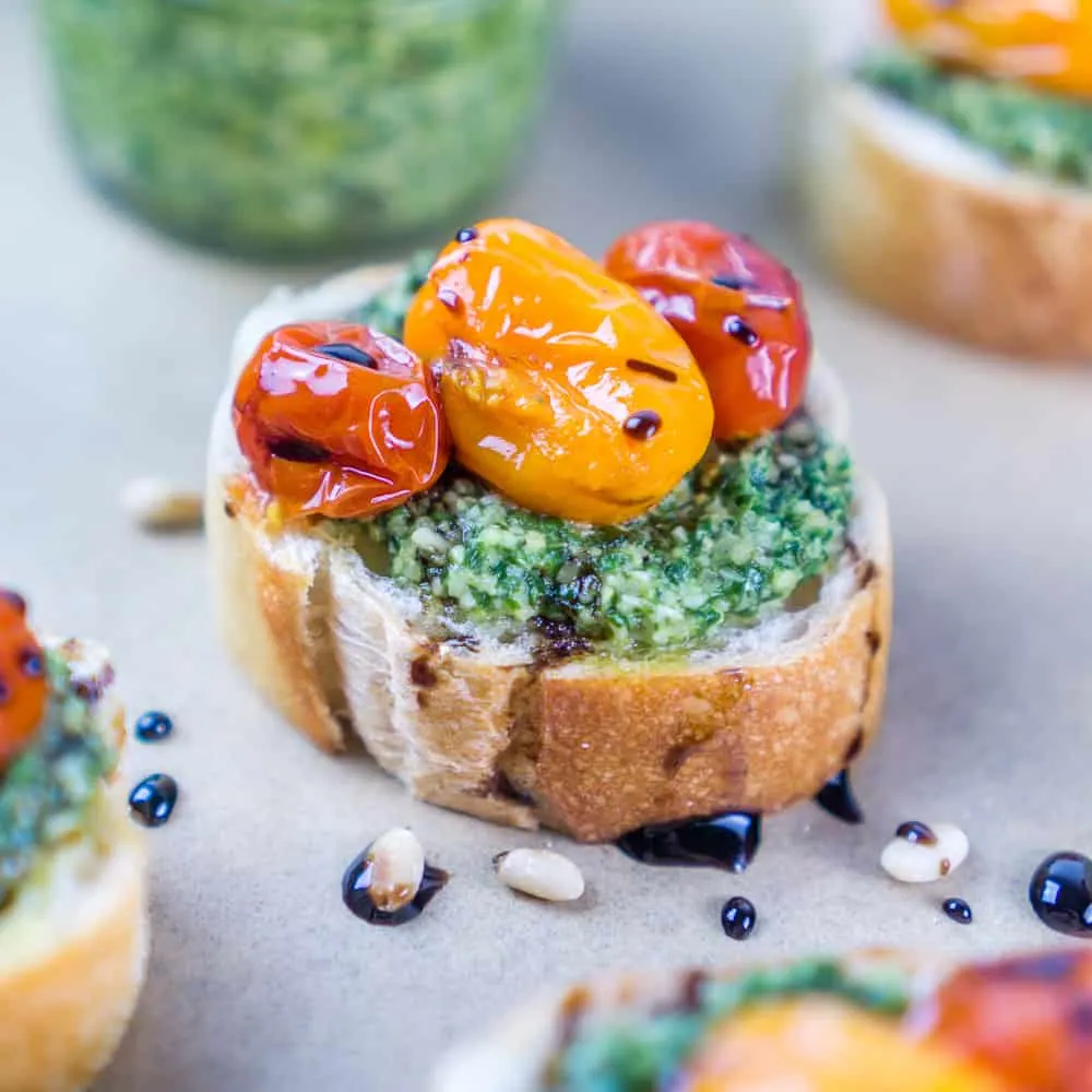 pesto and tomato crostini with balsamic glaze drizzle