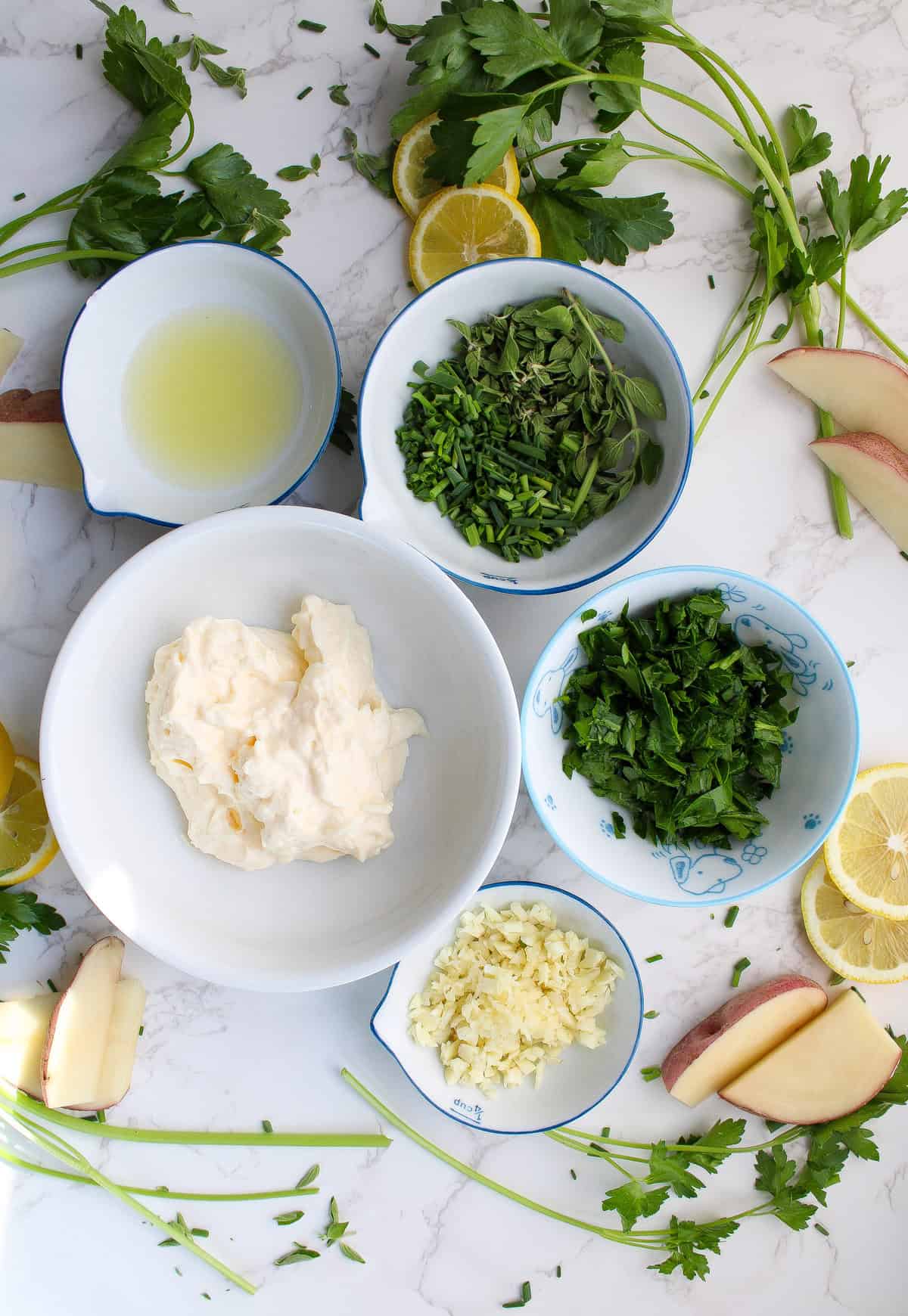 ingredients for garlic herb aioli including parsley, garlic, lemon juice and mayo